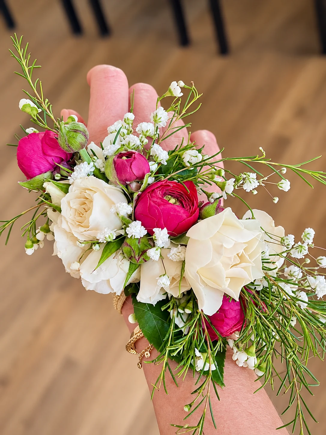 White roses and deep pink ranunculus wrist corsage